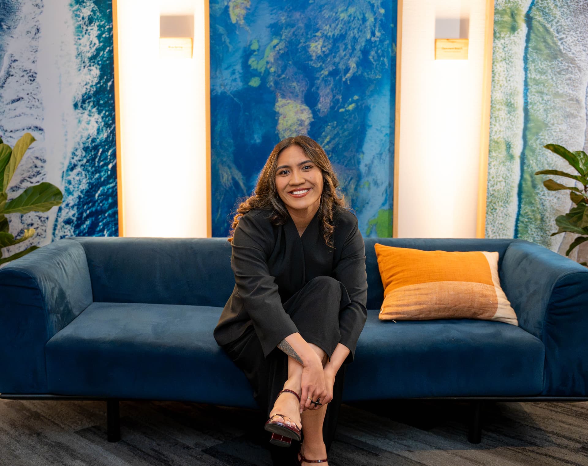 A portrait of a woman seated on a blue couch
