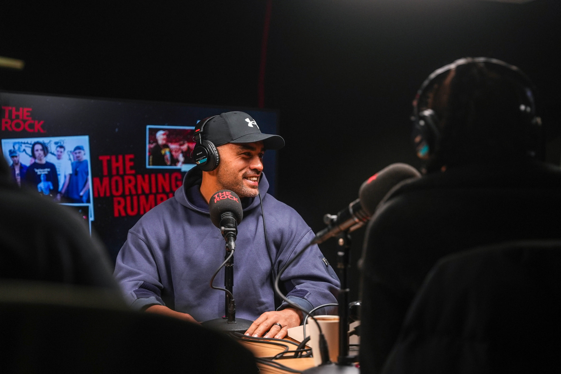 A guest smiling during a radio interview in the studio