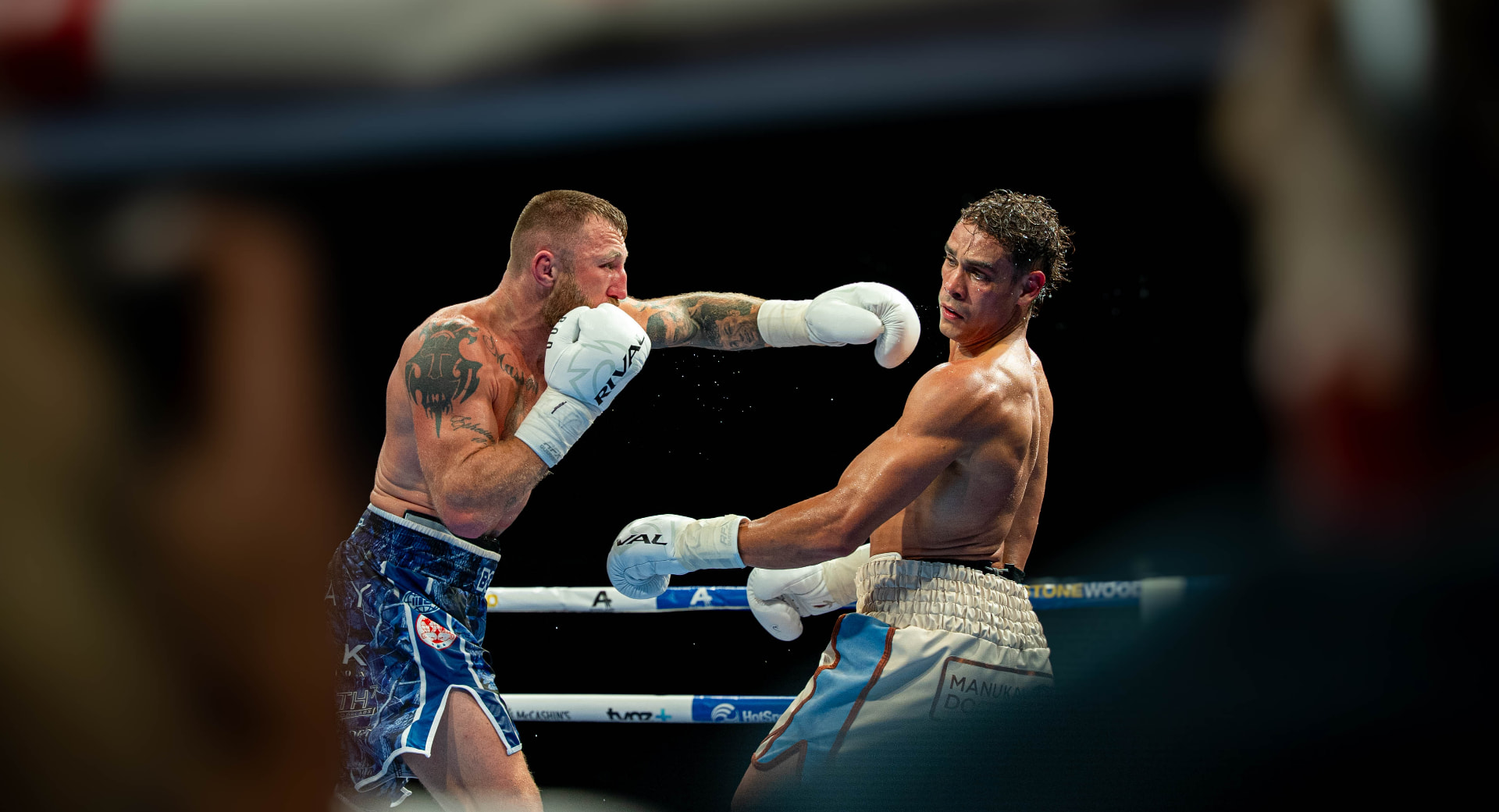 Two boxers trading punches under the lights