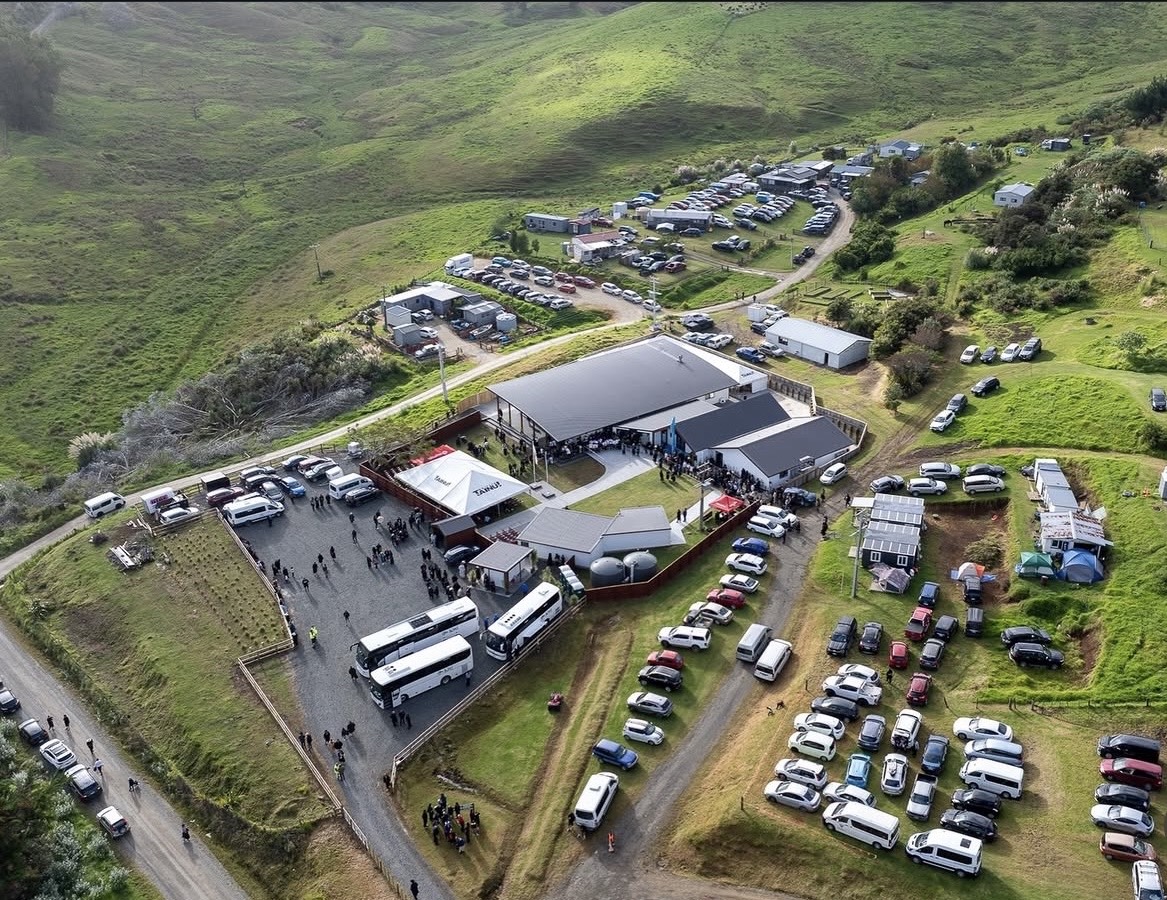 An aerial view of a large community gathering in green hills