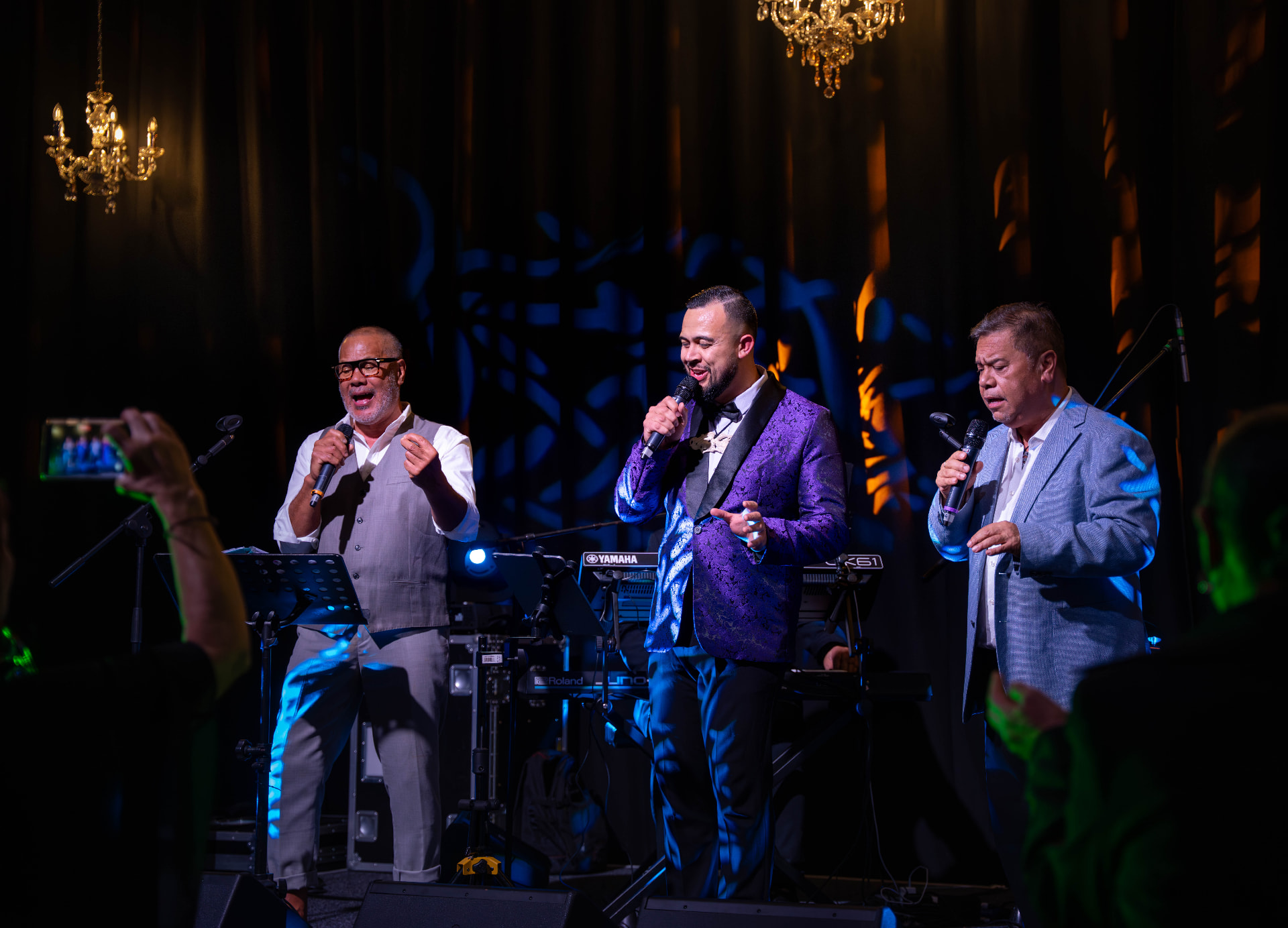 Three vocalists performing on stage